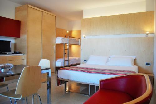 利尼亚诺萨比亚多罗阿尔巴托斯公寓酒店的一间卧室配有一张床和一把椅子,一间厨房