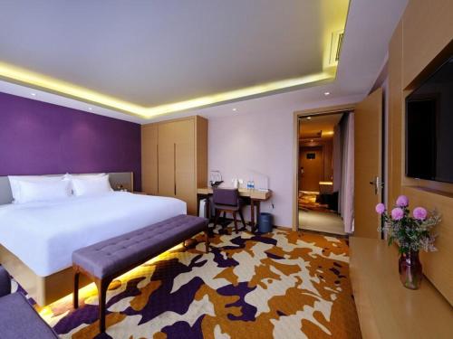 成都麗枫酒店·成都春熙路店的酒店客房设有一张大床和一张桌子。