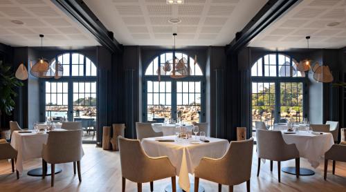 佩罗斯-吉雷克Castel Beau Site的餐厅设有白色的桌椅和窗户。