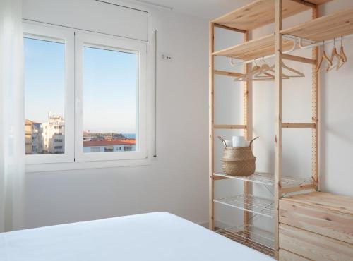 拉梅特拉·德·玛尔LA CALA BEACH DELUXE Apartments的一间卧室设有一张床、书架和窗户