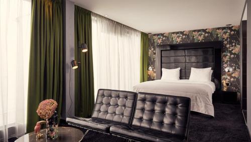 埃因霍温埃因霍温凡德瓦克酒店的一间卧室配有一张大床和一把椅子
