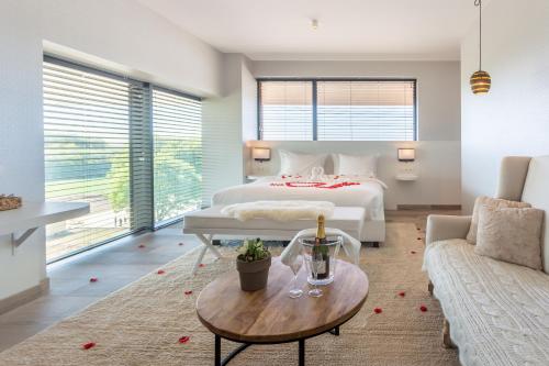 阿尔隆Van Der Valk Luxembourg Arlon的一间卧室配有一张床、一张桌子和一张沙发