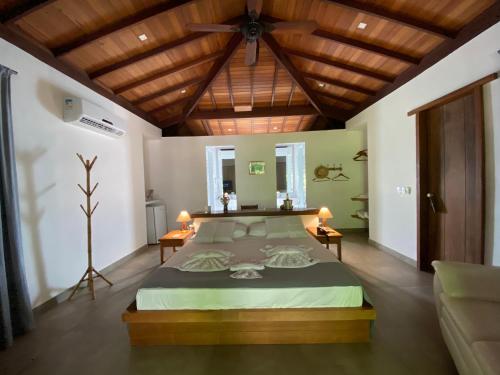 马劳Pousada Sitio da Bia的一间卧室设有一张带木制天花板的大床