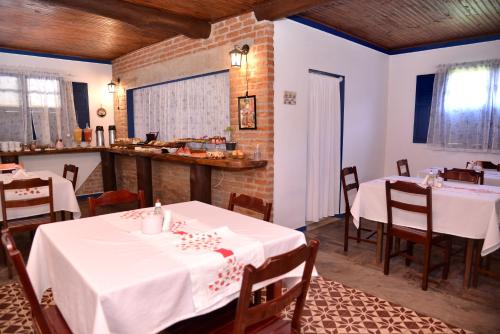 佩德拉阿祖尔Pousada Vale da Mata的餐厅设有白色的桌椅和柜台