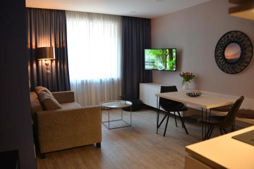 慕尼黑贝利布鲁中心酒店的客厅配有沙发和桌子