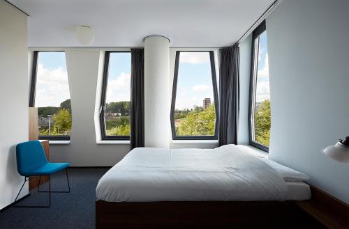 阿姆斯特丹The Social Hub Amsterdam West的一间卧室设有一张床和三个窗户。