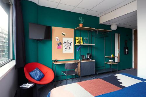 阿姆斯特丹The Social Hub Amsterdam West 4 star的一间卧室设有绿色的墙壁和红色的椅子