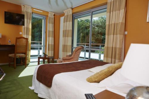 瑟松塞维涅Le Clos Champel Hôtel Restaurant Logis的酒店客房设有一张床和一个阳台。