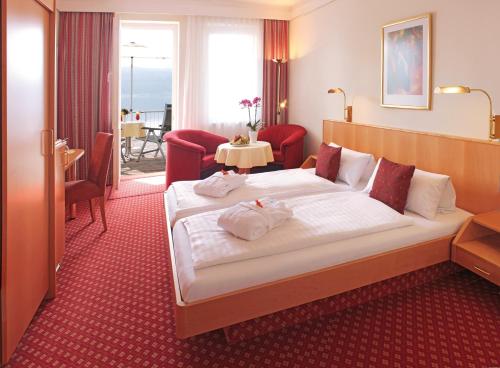 赖兴瑙Strandhotel Löchnerhaus的酒店客房设有一张大床和一张桌子。
