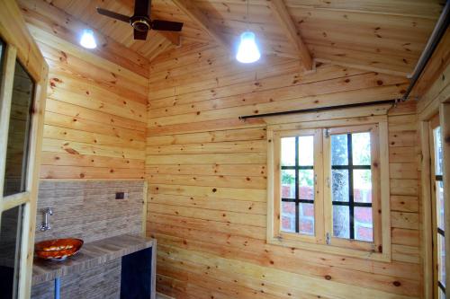 BanastarimCozywoods Hill Resort的小木屋浴室设有木墙和窗户