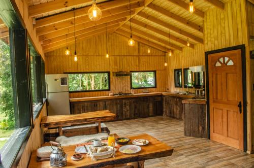 柴滕Cabañas Parque Michimahuida的一个带木墙和木桌的大厨房