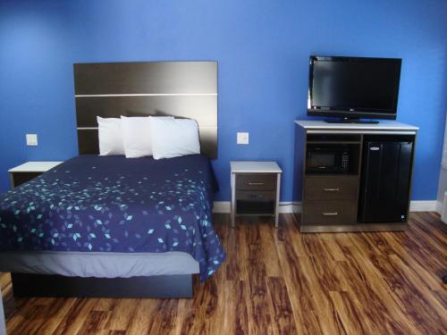 萨克拉门托Oasis Inn Sacramento- Elk Grove的一间卧室配有一张床和一台平面电视