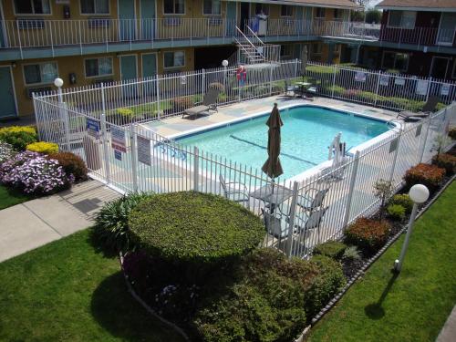 萨克拉门托Oasis Inn Sacramento- Elk Grove的游泳池周围设有白色围栏