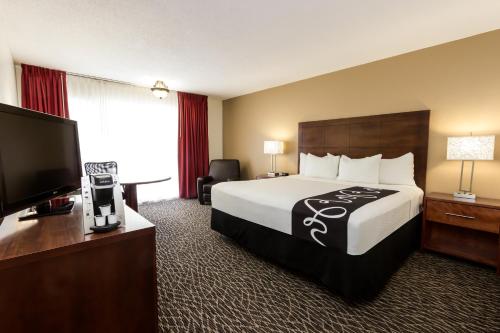 克利尔沃特La Quinta by Wyndham Clearwater Central的配有一张床和一台平面电视的酒店客房