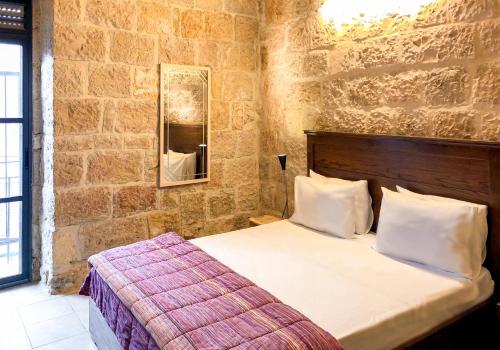 耶路撒冷新帝国酒店 的卧室配有一张石墙床