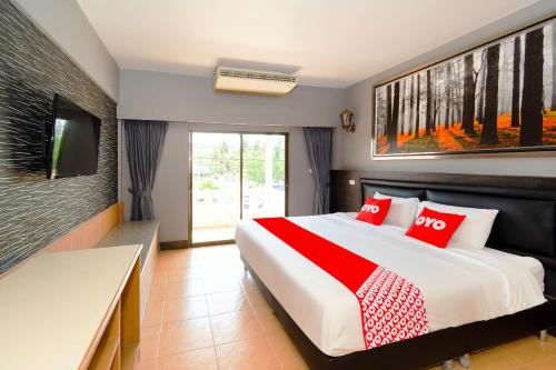 华欣OYO 765 Pom Pom Residence的一间卧室配有一张带红色枕头的大床