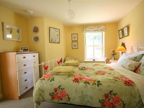 阿尔维斯考特Garden Cottage的一间卧室配有一张床、一个梳妆台和一扇窗户。