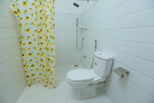 亭可马里Trinco Star Cabana的浴室设有卫生间和带向日葵的浴帘。