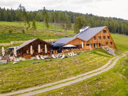 卢松Oberhauser Hütte Rodenecker - Lüsner Alm的一座位于草地山丘上的木制大建筑