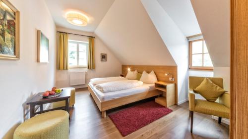 NovacellaHotel Brückenwirt的卧室配有一张床和一张桌子及椅子