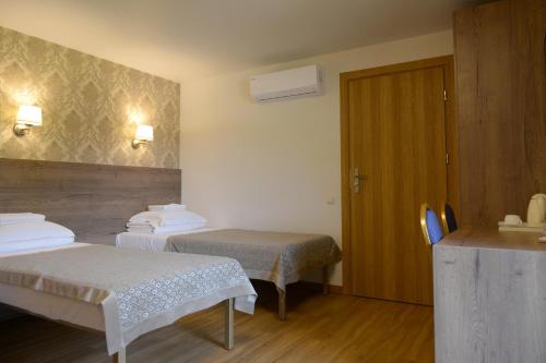 阿利图斯Dzūkijos dvaro "Oficina"的一间酒店客房,设有两张床和一扇门