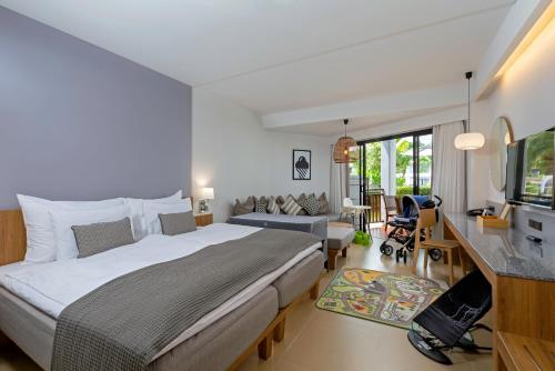 卡马拉海滩Sunwing Kamala Beach的一间带大床的卧室和一间客厅