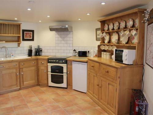 MereThe Folly at Castlebridge的厨房配有木制橱柜和白色家电