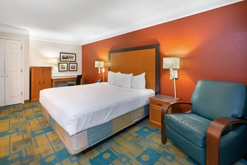 坦培凤凰城空港机场拉金塔套房酒店的酒店客房,配有一张床和一张蓝色椅子