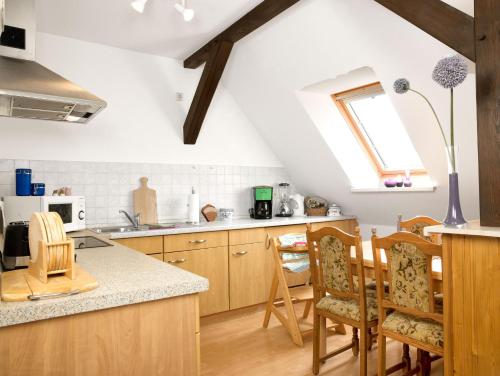 高尔维茨FeWo Windrose的阁楼厨房设有木制橱柜和窗户。