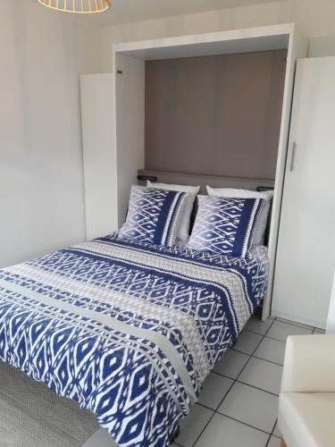 杜瓦讷内LE STUDIO DU RIS的一张带蓝色和白色床单及枕头的床
