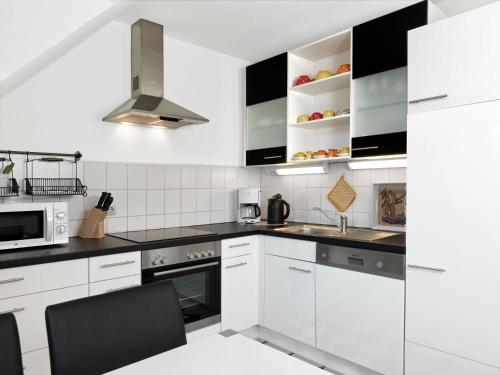 蒂门多夫Appartements Am Reiterhof Meerzeit的白色的厨房配有黑白电器
