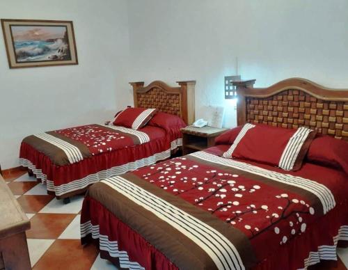Jojutla de JuárezHotel Imperial Jojutla的一间卧室配有两张红色棉被的床