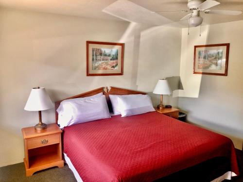 新奥尔良市Hiouchi Motel的一间卧室配有一张红色大床和两盏灯