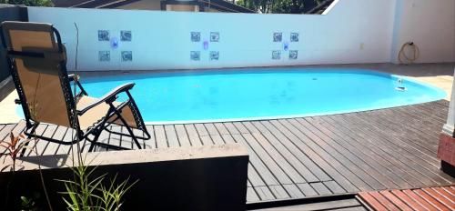 弗洛里亚诺波利斯Casa Ribeirao da Ilha的游泳池旁配有两把椅子和一把椅子