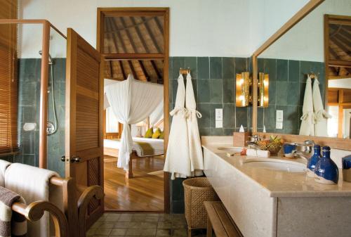 特尔罕都岛可可棕榈杜尼鲁的一间带水槽的浴室和一张位于客房内的床