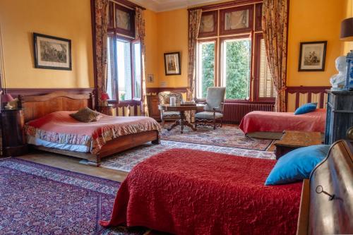 Buzançais薄荷璐堡酒店的一间卧室配有两张床和一张桌子及椅子