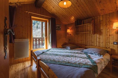 尚帕尼恩瓦努瓦茲L'arpont的小木屋内一间卧室,配有一张床