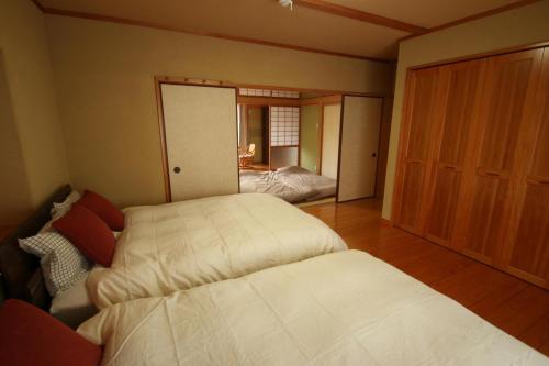 阿苏市Aso - House / Vacation STAY 79474的一间卧室设有两张床,一扇门通往卧室