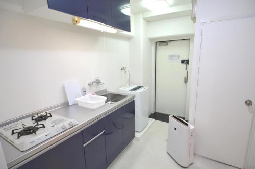 宫崎Comfort CUBE PHOENIX MIYAZAKI的厨房配有蓝色橱柜和水槽