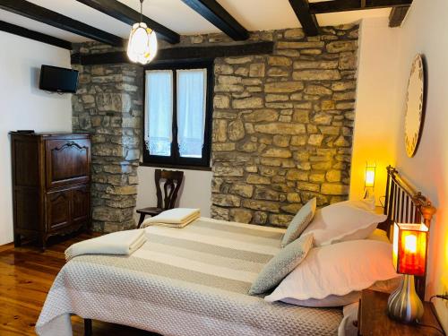 Urzainqui盎歌萨奇酒店的一间卧室设有一张床和石墙