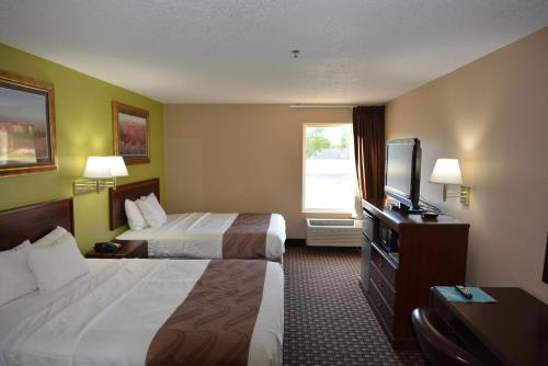 HazlehurstJameson Inn and Suites Hazelhurst的酒店客房设有两张床和一台平面电视。