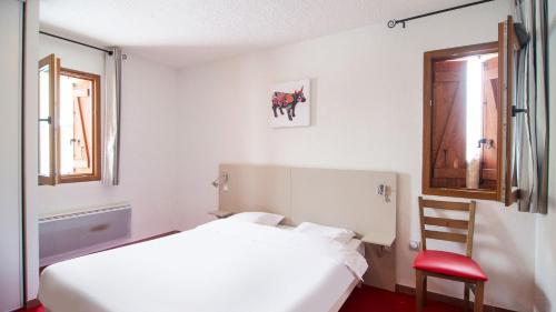 安格勒维卡西奥利伊萨德小屋公寓式酒店的卧室配有白色的床和红色椅子