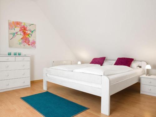 蒂门多夫Appartements Am Reiterhof Seepferdchen的卧室配有白色的床和梳妆台。