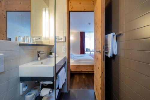 锡尔斯玛丽亚Arenas Resort Schweizerhof的浴室设有白色水槽和镜子