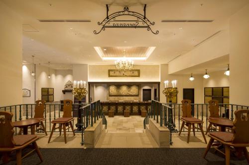 神户Hotel Monterey Kobe的大堂设有桌椅和吊灯。