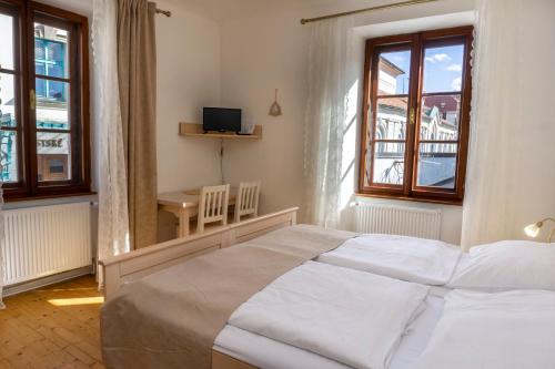 捷克克鲁姆洛夫Hotel Barbakan的卧室配有床、桌子和窗户。
