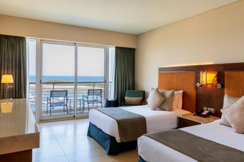 穆萨纳Barceló Mussanah Resort, Sultanate of Oman的酒店客房设有两张床和一个阳台。