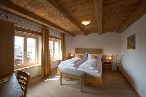 穆尔滕La Maison Salvagny的一间卧室设有两张床和两个窗户。