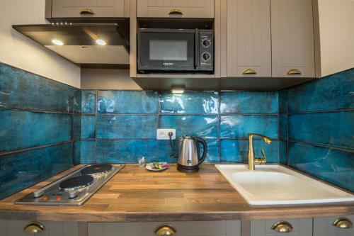 基辅Secret Apartments的厨房设有蓝色瓷砖墙壁和水槽