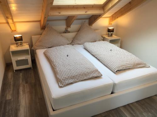 BruchhausenPenthaus Regine的卧室配有白色的床和2个枕头